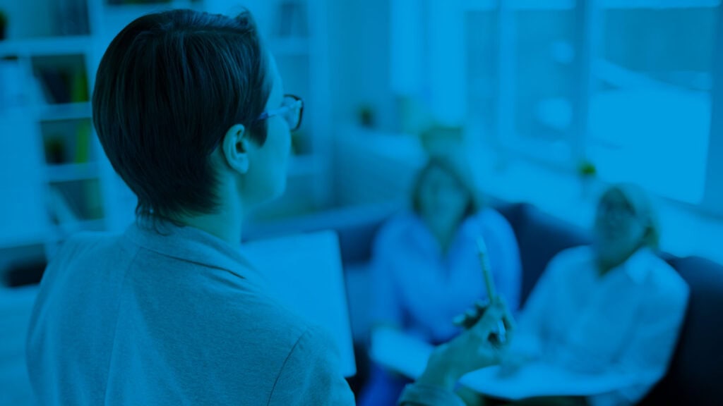 Riunione di team in ufficio con professionisti che discutono strategie e progetti. Ambiente luminoso.