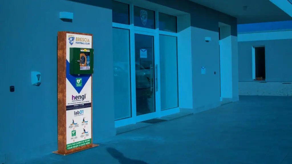 Pannello informativo con logo Brescia Calcio e pubblicit&agrave;, situato all'esterno di un centro sportivo.