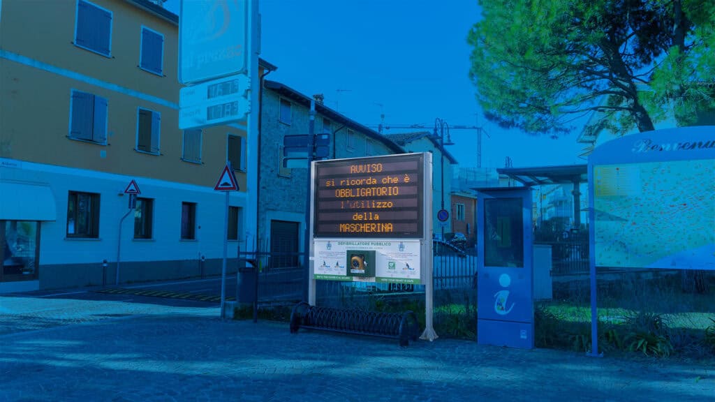 Pannello digitale con avviso di sicurezza pubblica in zona urbana.